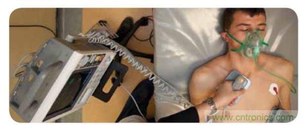 帶電極的醫院用除顫器。注意，患者身上有外部心電圖或心髒監護儀，從胸部的白色圓片(電極)和導聯(線)可看出來。